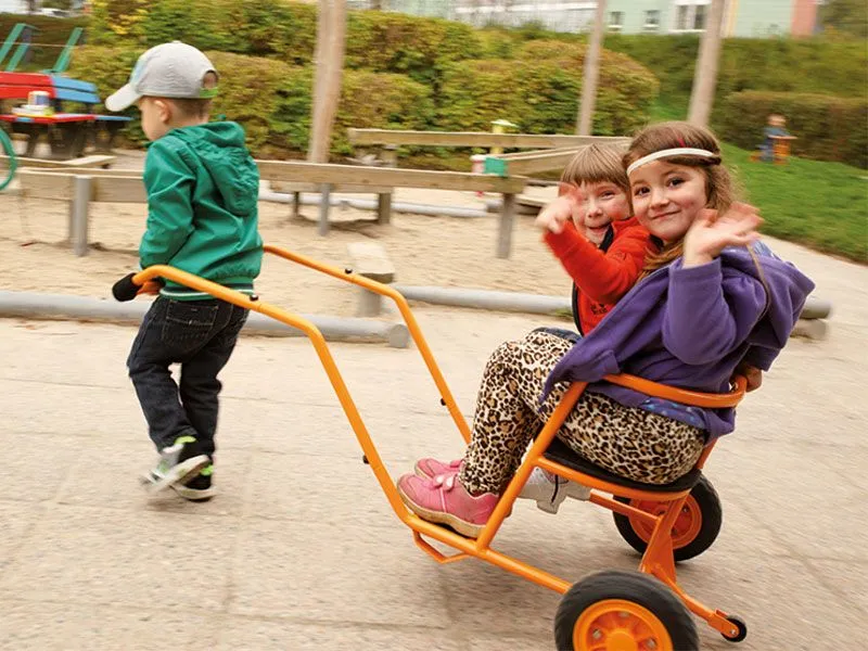 Children happily playing with the rickshaw on the playground Children happily playing with the rickshaw on the playground
